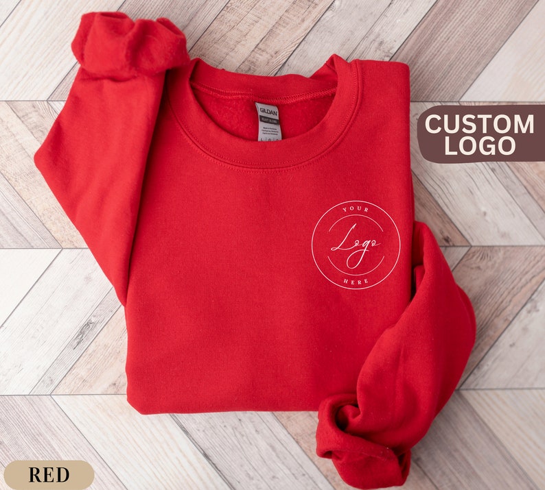 May include: Red crewneck sweatshirt with a white circle logo that says "Your Logo Here" on the front.