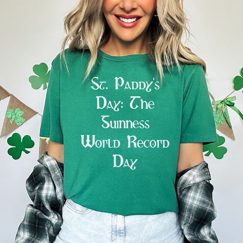 May include: A green t-shirt with white text that reads "St. Paddy's Day: The Guinness World Record Day".