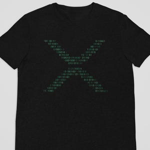 May include: Black t-shirt featuring a green binary code design in the shape of an X. The binary code is composed of ones and zeros, creating a tech-inspired graphic. A dark, casual tee for everyday wear.