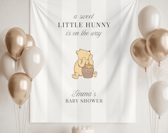 May include: A baby shower scene with a white and gold color scheme. A banner with the text "a sweet LITTLE HUNNY is on the way" and a Winnie the Pooh illustration is the focal point. Balloons, gifts, and a cake complete the festive decor.