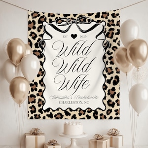 Op de afbeelding: Een feestachtergrond met een luipaardprintrand en de woorden "Wild Wild Wife" in elegant schrift. De achtergrond bevat de tekst "Samantha's Bachelorette Charleston, NC" en is versierd met ballonnen, cadeaus en een taart.