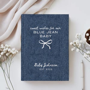 May include: A navy blue baby announcement card with a denim texture. The card features the text "sweet wishes for our BLUE JEAN BABY" and "Baby Johnson EST 2026" in white script. A white bow graphic is centered on the card.