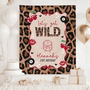 May include: A leopard print backdrop with a central design that reads "Let's get WILD" and "Hannah's 21st Birthday." The design includes cherries, lips, and a cake illustration. White and gold balloons are visible.