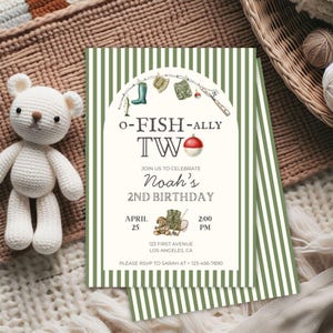 May include: A birthday invitation with a fishing theme. The invitation features green and white stripes, with the text "O-FISH-ALLY TW" and "Noah's 2nd Birthday." A white crocheted teddy bear is on the left.