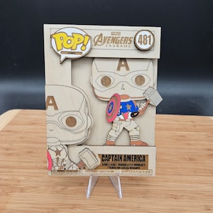 May include: A wooden Captain America Pop! figure from the Marvel Avengers Endgame movie. The figure is assembled from multiple pieces and features a bobbling head. The figure is displayed on a clear plastic stand.