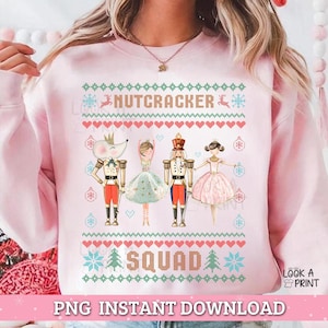 Könnte beinhalten: Ein hellrosa Sweatshirt mit einem festlichen Design. Die Worte "NUTCRACKER SQUAD" sind im Stil eines Weihnachtspullovers dargestellt. Die Grafik enthält Illustrationen von Figuren aus dem Nussknacker-Ballett, wie einem Mäusekönig, einer Ballerina und einem Nussknackersoldaten.