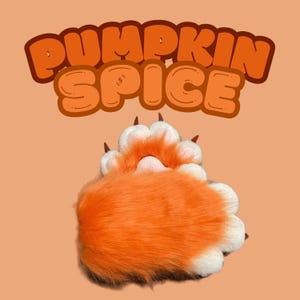 Puede incluir: Pata peluda naranja y blanca con garras, que se asemeja a una pata de gato. La pata es parcialmente visible, con el texto "PUMPKIN SPICE" en letras naranjas arriba.