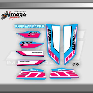 May include: A set of pink and blue Yamaha Banshee 350 motorcycle graphics decals. The decals feature the words "Banshee 350", "Yamaha", and "2 Stroke Twin" in white and black lettering. The decals are designed for a special edition motorcycle.