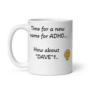 May include: White ceramic mug with a black and white text design that reads "Time for a new name for ADHD... How about "DAVE"?..". A yellow smiley face is to the right of the text.