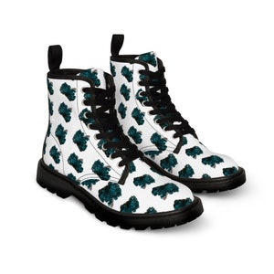 May include: White lace-up boots with a teal and white pattern of abstract shapes. The boots have black laces and a black sole.