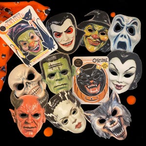 May include: A collection of vintage Halloween masks featuring classic monster and character designs. Masks include a witch, vampire, Frankenstein's monster, skull, devil, and wolf. Some masks are still in their original packaging, with the text "COLOR BRITE COSTUME".