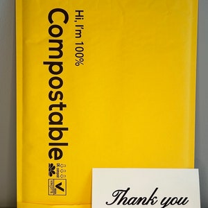 Puede incluir: Un sobre de env&iacute;o compostable amarillo con el texto "Hi, I'm 100% Compostable" y un logotipo. Una tarjeta blanca con el texto "Gracias" y un peque&ntilde;o dise&ntilde;o de rama est&aacute; delante del sobre.