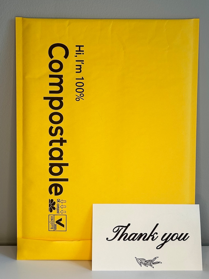 Puede incluir: Un sobre de env&iacute;o compostable amarillo con el texto "Hi, I'm 100% Compostable" y un logotipo. Una tarjeta blanca con el texto "Gracias" y un peque&ntilde;o dise&ntilde;o de rama est&aacute; delante del sobre.