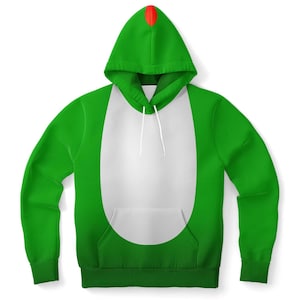 May include: Green hooded sweatshirt with a white oval shape on the front. The hood has a red tip.