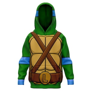 Op de afbeelding: Groen hoodie met een schildpadpantserontwerp van de Teenage Mutant Ninja Turtles. Het schildpadpantser is bruin met een bruine riem en een gouden gesp met de letter "L" erop. De mouwen hebben blauwe strepen.