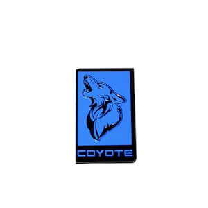 May include: A black and blue emblem with a howling coyote silhouette and the word "COYOTE" in white lettering.
