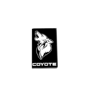May include: Black and white graphic of a coyote howling with the word "COYOTE" in white text below the image.