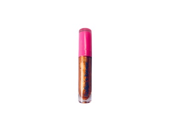 May include: A clear glass bottle with a pink lid filled with a metallic gold liquid lip gloss. The bottle has the text "Liquid Luxe" printed on it in blue.
