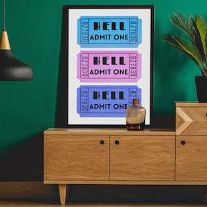 May include: A framed print with three colorful tickets that read "HELL ADMIT ONE" on a wooden dresser with a plant and a glass bottle.