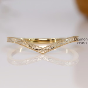 May include: A gold-coloured, V-shaped ring with a textured surface. The ring features a delicate, engraved pattern and is set against a white background. The text "Diamond crush" is visible on the right side of the image.