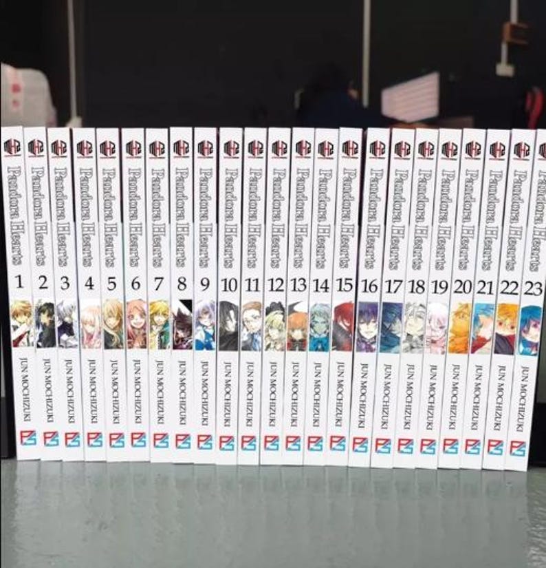 May include: A collection of 23 manga volumes of Pandora Hearts, a dark fantasy series by Jun Mochizuki. The spines are white with black text and illustrations of characters from the series.