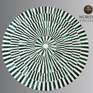 May include: Circular table top with a geometric pattern of alternating green and white stripes radiating from the center. The design creates a visual effect, resembling a target or a sunburst. The table top is likely made of stone or a similar material.