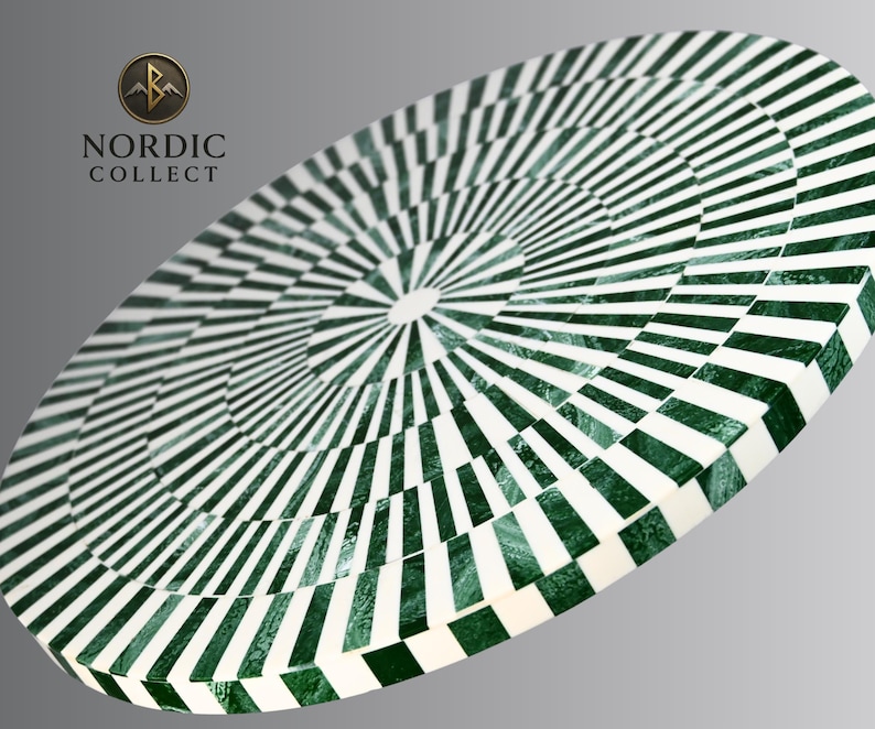 May include: An oval-shaped decorative table with a green and white geometric pattern. The design features concentric circles of alternating stripes and squares, creating a striking visual effect. The table's surface is smooth and reflective, with a glossy finish.