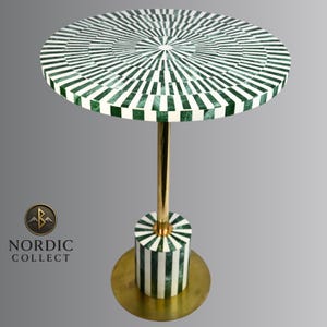 May include: A round side table with a green and white striped top. The table has a gold-colored metal stem and base. The base is cylindrical with matching green and white stripes. The table is approximately 24 inches tall.