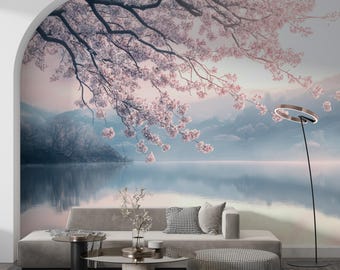 May include: A living room with a gray couch and two round coffee tables. The wall behind the couch features a mural of a lake with mountains and a cherry blossom tree.