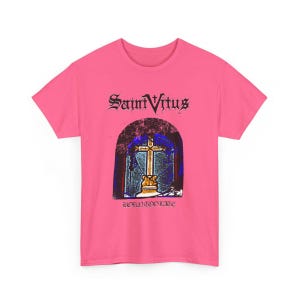 May include: Pink t-shirt with a black and white graphic of a stained glass window with a cross inside. The text "Saint Vitus" and "Born Too Late" are printed on the shirt.