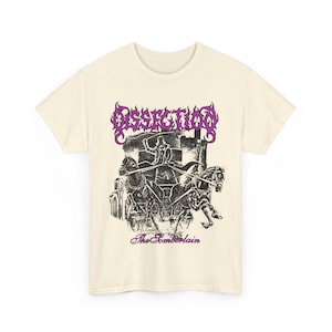 May include: Cream-colored t-shirt featuring a black and white illustration of a chariot pulled by horses, with a figure wielding a sword. The word "Dissection" is in purple above the image, and "The Somberlain" is below.