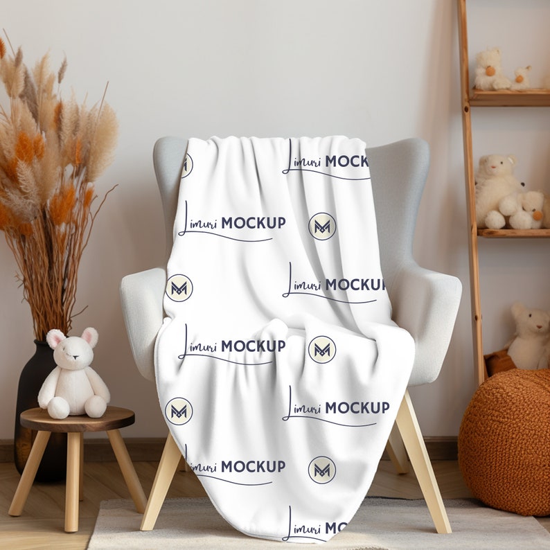 Pu&ograve; includere: Coperta bianca con un motivo ripetuto del testo "imuri MOCKUP" e una "M" stilizzata in un cerchio. La coperta &egrave; drappeggiata su una poltrona grigia con gambe in legno.