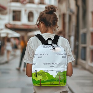 May include: White backpack with a green, yellow, and blue nature scene design. The backpack has black straps and a zipper closure. The text "OVERLAY MOCKUP PNG" is repeated on the backpack.