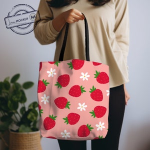 Puede incluir: Una bolsa de tela rosa con asa negra y un patr&oacute;n repetido de fresas rojas y flores blancas.