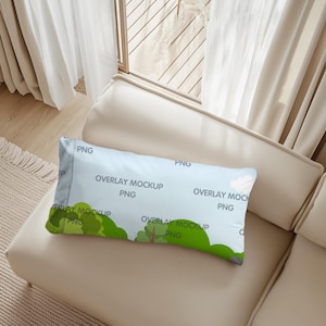May include: A rectangular pillow mockup with a light blue sky background and green trees. The text "OVERLAY MOCKUP PNG" is repeated across the pillow. The pillow is resting on a beige sofa.