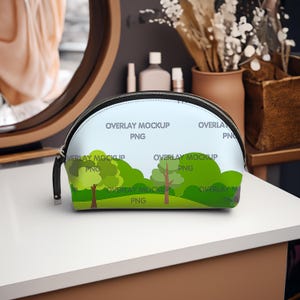 May include: A black and white cosmetic bag with a landscape design featuring trees and green foliage. The bag has a black zipper and handle. The text "OVERLAY MOCKUP PNG" is printed on the bag.
