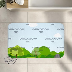 Op de afbeelding: Een blauwe en witte badmat met een groen, geel en bruin landschapsontwerp. De mat heeft de tekst "OVERLAY MOCKUP PNG" die herhaald wordt over de hele mat.