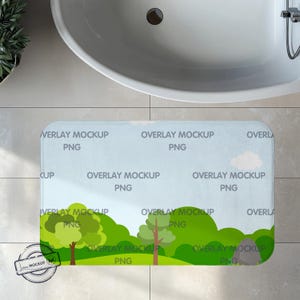 May include: A blue and green bath mat with a cartoon landscape design. The mat has the text "Overlay Mockup PNG" repeated throughout the design.