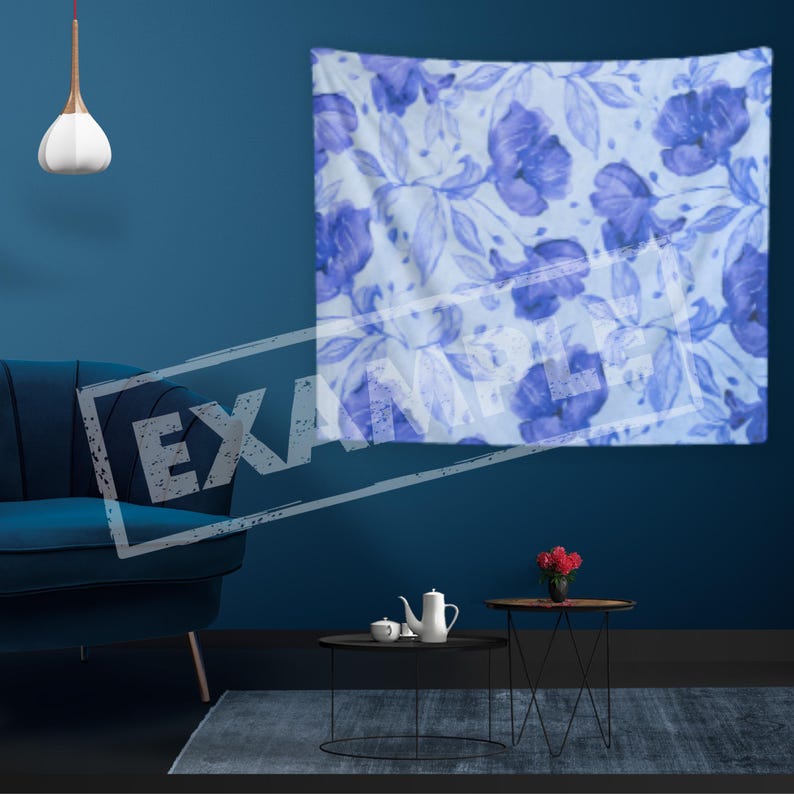May include: A blue and white floral tapestry with a watercolor design hangs on a dark blue wall. The tapestry features a repeating pattern of blue flowers and leaves on a white background.