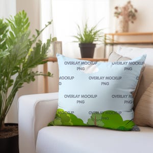 May include: A light blue throw pillow with a repeating pattern of white clouds and green trees. The pillow has the text "Overlay Mockup PNG" repeated on it.