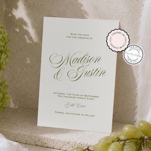 May include: A white rectangular save the date card featuring dark green text that reads Madison & Justin, Saturday, the third of September two thousand twenty eight, Gold Coast, and formal invitations to follow, with two circular decorative stamps.