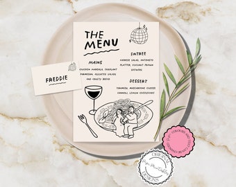 May include: A beige menu card with black text and illustrations, including a disco ball and a wine glass. The menu lists mains, entrees, and desserts. A matching name card reads "FREDDIE". The menu is on a beige plate with a sprig of greenery.