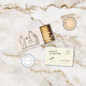 Puede incluir: Un juego de dos cajas de cerillas con ilustraciones personalizadas. La primera caja de cerillas tiene una pareja de pie en un bar con un corazón y el texto "The Perfect Match". La segunda caja de cerillas tiene una bola de discoteca, dos copas de martini y el texto "Mollie & Dalton 27.03.2027".