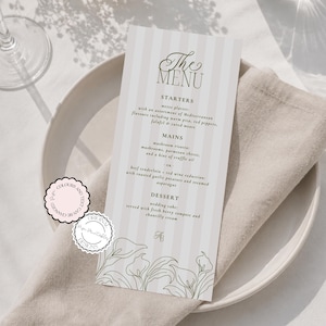 May include: A vertical menu card with light pink and white vertical stripes, featuring green text and a line-art floral border at the bottom. The text reads The Menu, Starters, Mains, and Dessert, with specific food items listed below each section.
