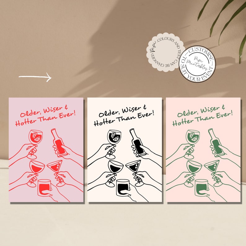 May include: Three printable cards with a pink background and black line drawings of people raising glasses of wine and a bottle. The text on the cards reads "Older, Wiser & Hotter Than Ever!"