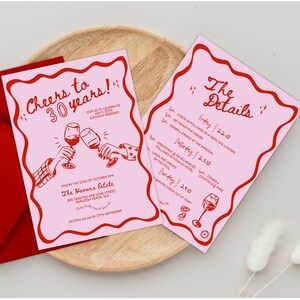 Puede incluir: Tarjetas de invitaci&oacute;n rosas y rojas con un dise&ntilde;o caprichoso. Las tarjetas presentan una ilustraci&oacute;n dibujada a mano de dos personas brindando con copas de vino. El texto en las tarjetas dice "Cheers to 30 years!" y "The Details".