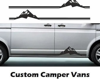 May include: A white van with black mountain decals on the side. The decals are in the shape of mountains with a black outline. The text "Custom Camper Vans" is printed below the van.