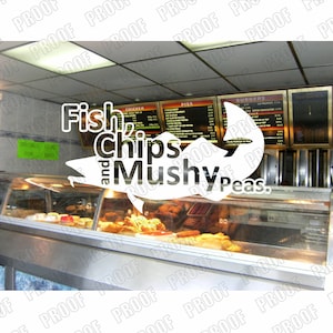Könnte beinhalten: Ein weißes Schild mit dem Text "Fish and Chips and Mushy Peas." Das Schild befindet sich vor einem Ladenfenster mit einer Essensauslage. Der Laden hat eine Speisekarte mit den Worten "Chicken", "Pies" und "Burgers".