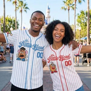 Könnte beinhalten: Zwei Personen tragen passende Baseball-Trikots. Eines ist weiß mit blauen Nadelstreifen und das andere ist weiß mit roten Nadelstreifen. Beide Trikots zeigen "Mr. Potato Head" und die Nummer "00".
