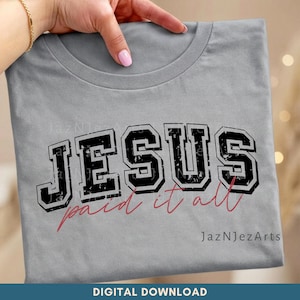 Puede incluir: Una camiseta gris claro con la palabra "JESUS" en negro, con un estilo universitario desgastado. Debajo, la frase "paid it all" está escrita en cursiva, en rojo. El texto "JazNjezArts" está en la esquina inferior derecha.